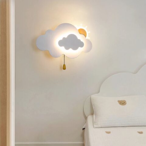 En la pared del dormitorio de un niño hay un aplique con forma de nube y sol, iluminado y colgado en la pared.