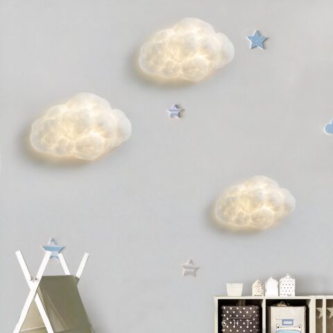Tres apliques blancos en forma de nube se iluminan sobre una pared blanca.