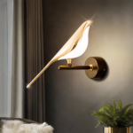 Sobre un fondo negro, un aplique dorado con forma de pájaro moderno.