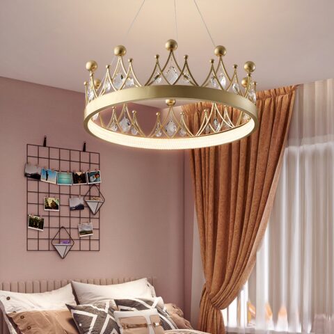 Lámpara de araña para la habitación de un bebé en forma de corona dorada, con piedras de cristal en la corona, en una habitación con paredes rosas