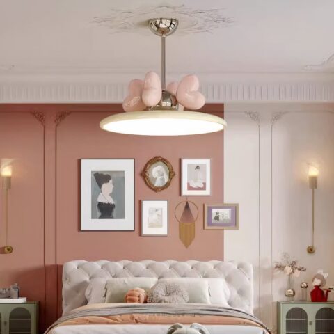 Araña para cuarto de niños con corazones rosas, colgando encima de una cama