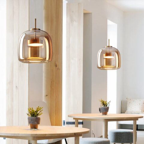 Colgante LED de cristal ahumado con un diseño moderno en un comedor encima de una mesa frente a un espejo