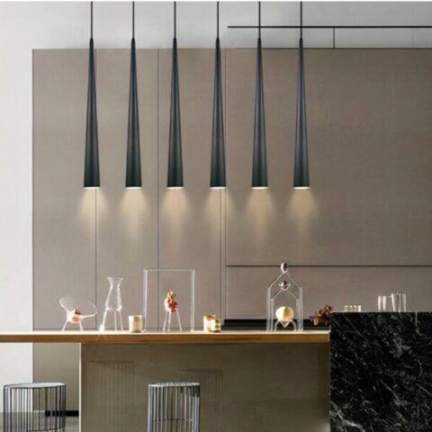 Moderna lámpara colgante en forma de cono, presentada varias veces y alineada encima de una mesa de cocina