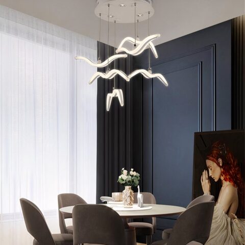 Lámpara colgante LED de estilo nórdico para pájaros presentada sobre una mesa de comedor