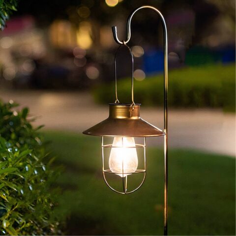 Luz LED retro para exteriores alimentada por energía solar sobre un fondo verde por la noche