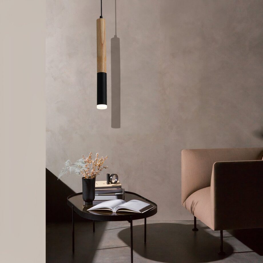 Colgante de madera LED en forma de tubo negro y beige, suspendido sobre una mesa de centro