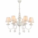 Lámpara barroca blanca en forma de candelabro con perlas decorativas colgantes y 6 pantallas clásicas con las bombillas encendidas. Sobre fondo blanco.