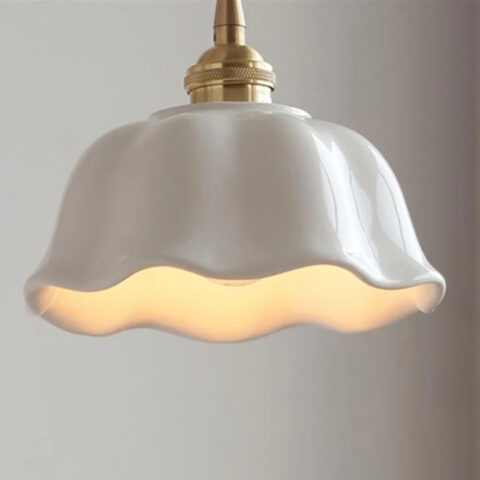 Lámpara colgante de cerámica ondulada blanca al estilo vintage de una antigua granja, iluminada sobre fondo blanco.