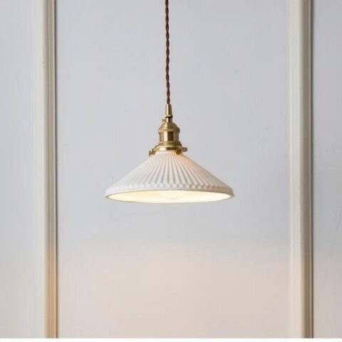 sobre un fondo blanco se aprecia una suspensión de cerámica blanca y cobre de estilo vintage