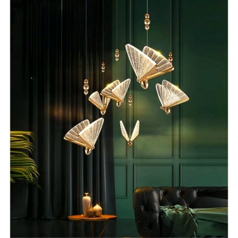 en un salón con tonos marrones verdosos oscuros, vemos una lámpara colgante dorada y transparente con forma de mariposa