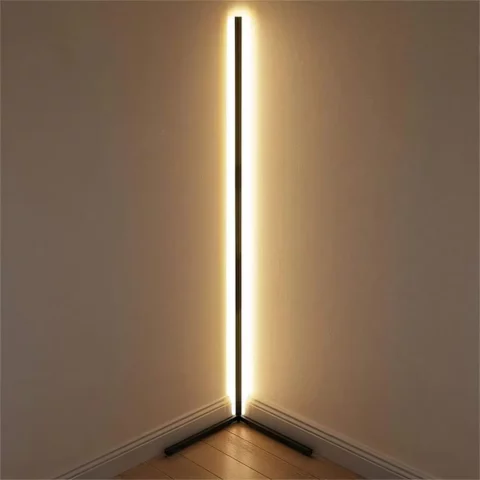 Lampadaire d’angle LED intelligent connecté, design minimaliste noir, lumière RGB personnalisable, installé dans l'angle d'une chambre face à un mur, réfléchissant ainsi son halo de lumière.