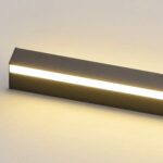Aplique de pared LED lineal encendido con luz cálida difusa sobre pared clara